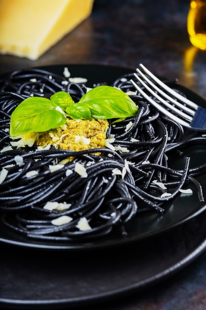 Black spaghetti with pesto sauce, basil and parmesan cheese