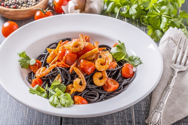 Foto spaghetti neri con gamberi e pomodoro.