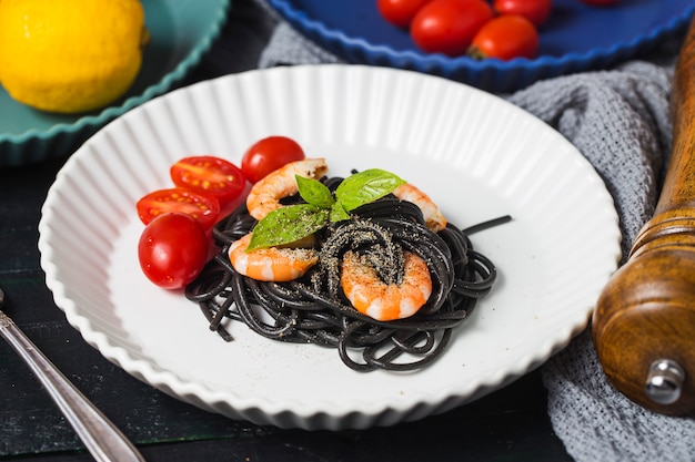 Black spaghetti with prawns on white plate