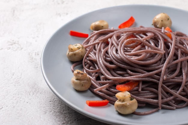 Photo black spaghetti with red pepper on a plate korean food