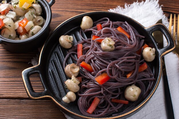 Photo black spaghetti with red pepper on a plate korean food