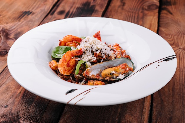 Black spaghetti with seafood on white plate