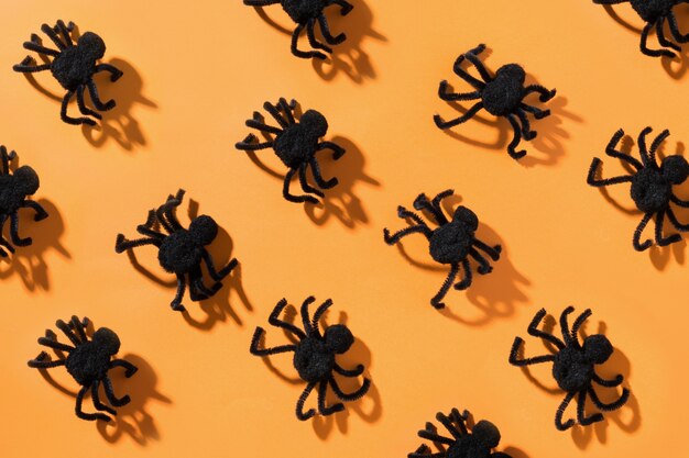 Photo black spiders on orange view from above open composition halloween party pattern