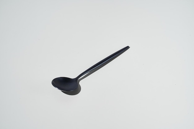 Black spoons on grey background View from top