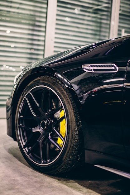 Black sport model car in front of the garage