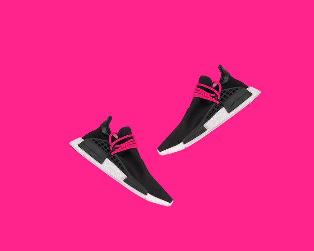 Black sports shoes on pink color wall