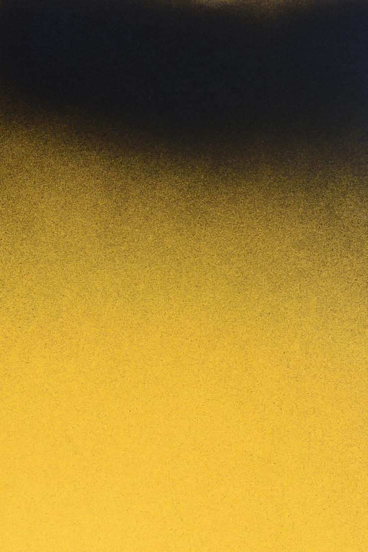 Black spray paint on a yellow colored paper background