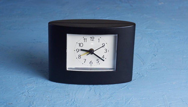 black square clock on light blue background