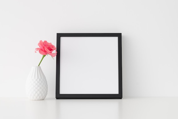 Black square frame mockup with pink rose in a vase