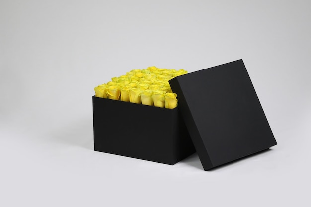 Black square gift flower packaging box with yellow roses inside and opened lid