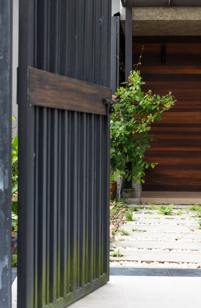 black stell door fence entrance to home with cement block and white stones walkway 
