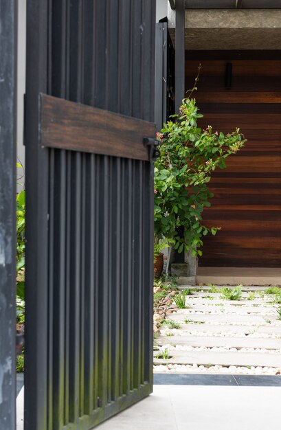 Black stell door fence entrance to home with cement block and white stones walkway 