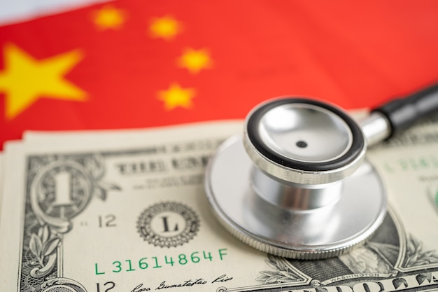 Black stethoscope on China flag background with US dollar banknotes, Business and finance concept.