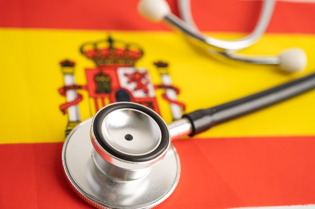 Фото Черный стетоскоп на фоне флага испании, концепции бизнеса и финансов.