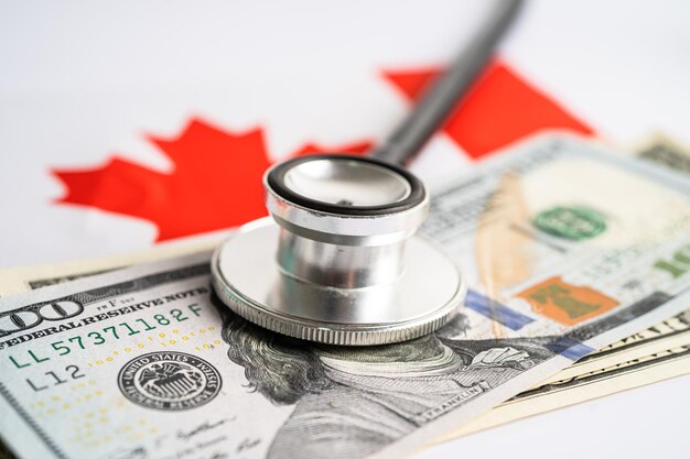 Black stethoscope with US dollar banknotes Canada flag background Business and finance concept