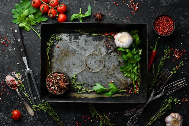 Black stone background with kitchen utensils spices and herbs Top view Free space for text