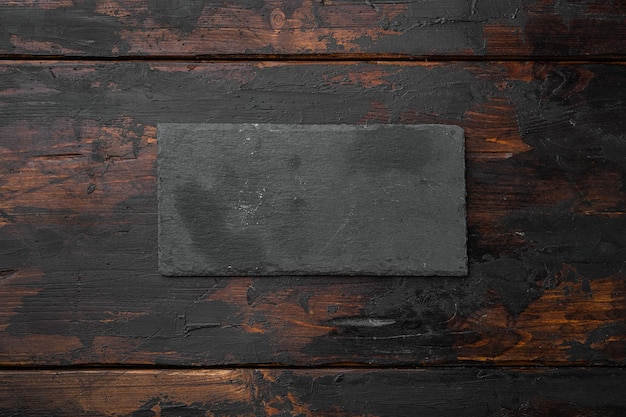 Black stone cutting board set with copy space for text or food with copy space for text or food top view flat lay on old dark wooden table background