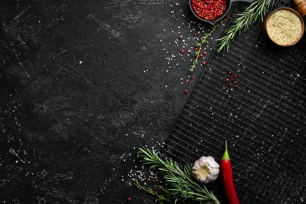 写真 黒い石の食べ物の背景は黒い背景にハーブや野菜をスパイスします上面図あなたのテキストのための空きスペース