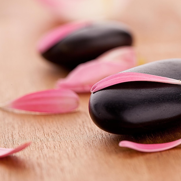 black stone with leaves on wooden background