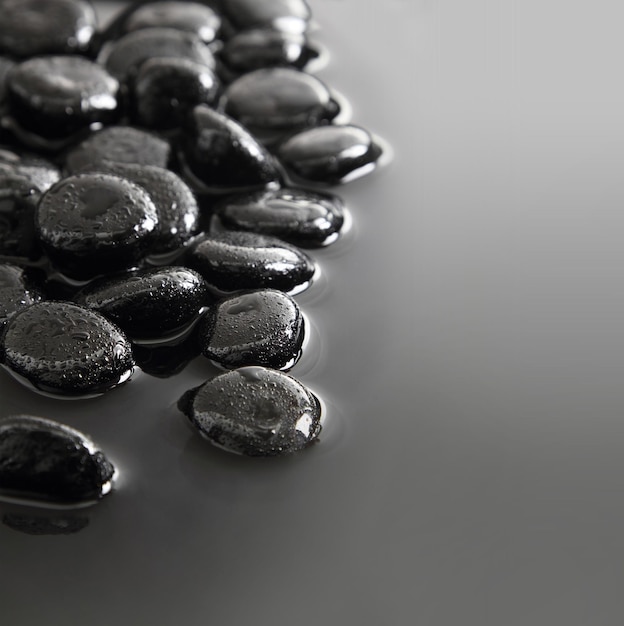 Black stones on calm water background