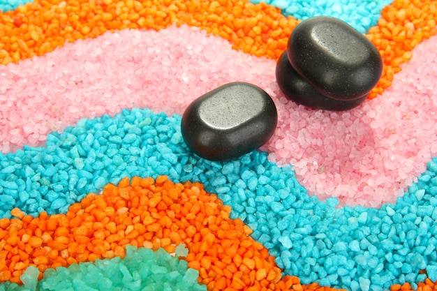 Black stones on colorful crystals of sea salt