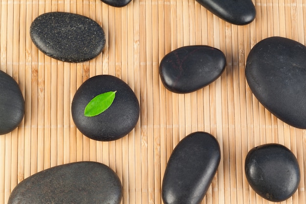 Black stones with a leaf on one of them