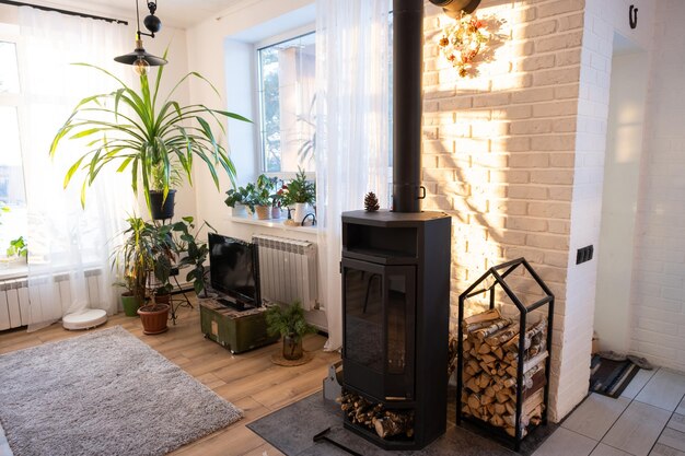 Black stove fireplace in interior of house in loft style Alternative eco-friendly heating warm cozy room at home burning wood