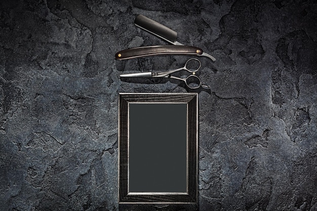 Black Stright Razor Scissors And Empty Frame In Barbershop Concept On Stone Slate Background