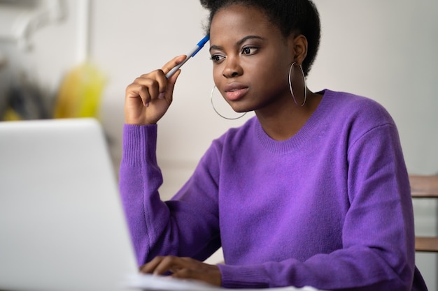 Black student woman preparing for exam online, watching video course. Online education