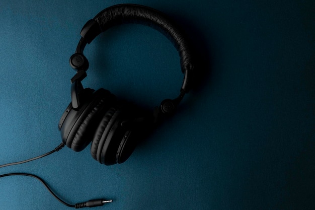 Black studio headphones with blue background and space for text.