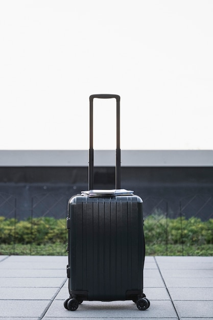 Black suitcase sitting on the sidewalk