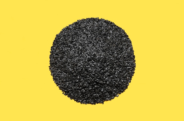 Black sunflower seeds top view Pile of sunflower seeds isolated on a yellow background