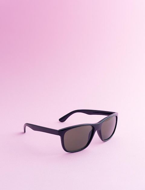 Black sunglasses over pink background