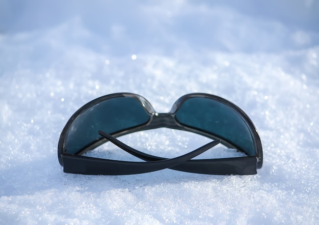 Foto occhiali da sole neri sulla neve