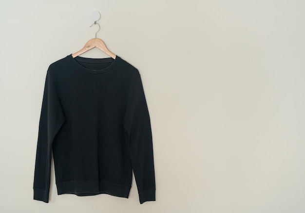 Photo black sweater hanging on hanger