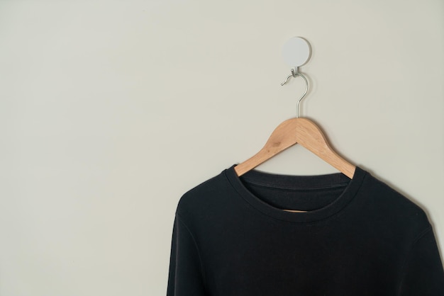 Black sweater hanging on hanger