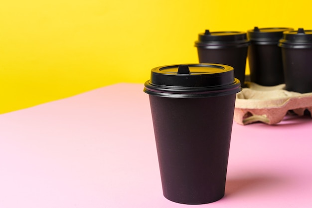 Photo black take away coffee cups in holder on table