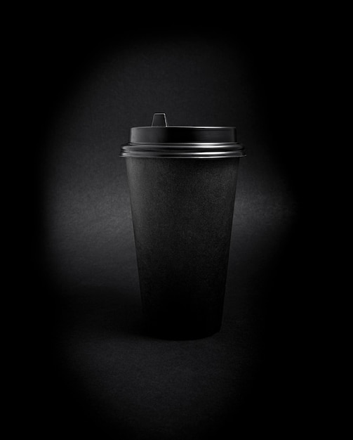 Foto tazza di caffè di carta da asporto nera sopra il nero