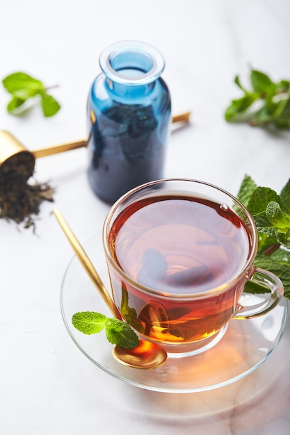 Black tea in glass transparent mug with mint leaves soothing tea antistress