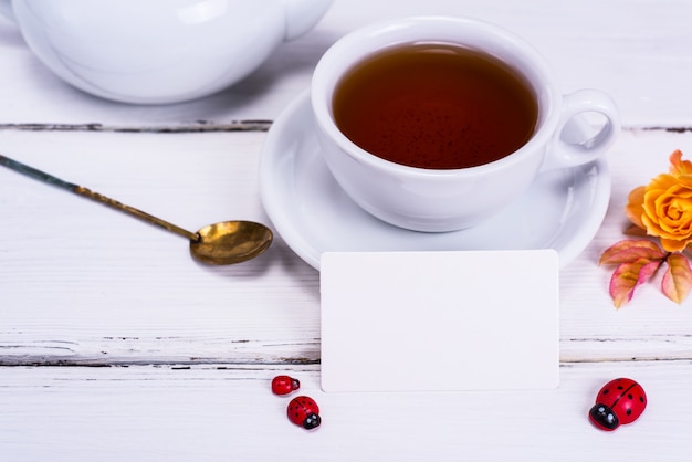 Black tea in a round white cup with a saucer 