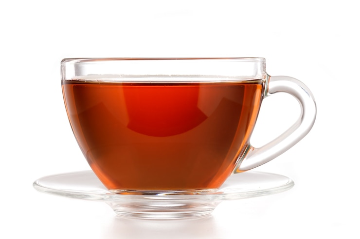 Photo black tea in a transparent glass cup on a white background