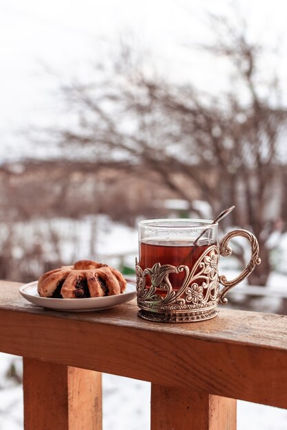 Photo black tea in vintage cup and homemade poppy seeds bun