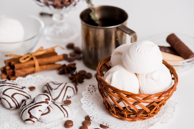 Black tea with cookies and cinnamon on a white wooden background