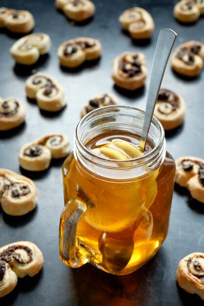 Black tea with lemon in jar cup and biscuits