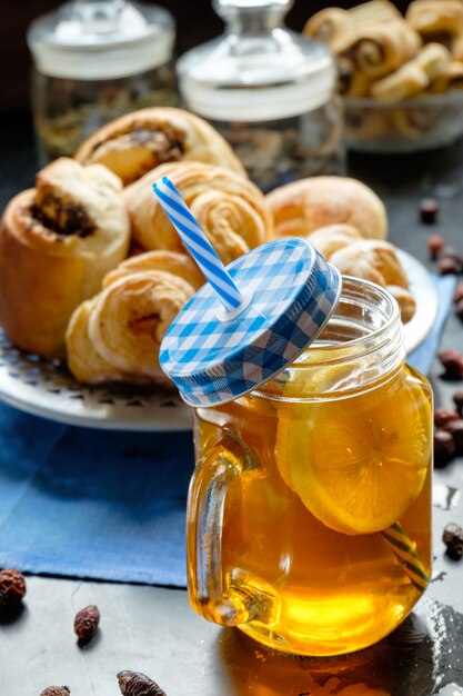 Black tea with lemon in jar cup and biscuits