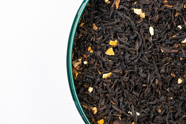 Black tea with orange peel and cinnamon closeup top view