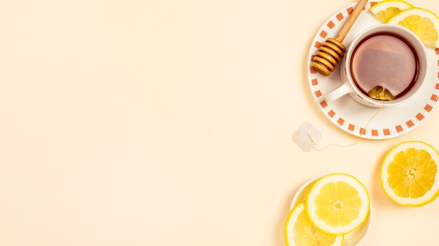 Black tea with slice of fresh lemon on beige background