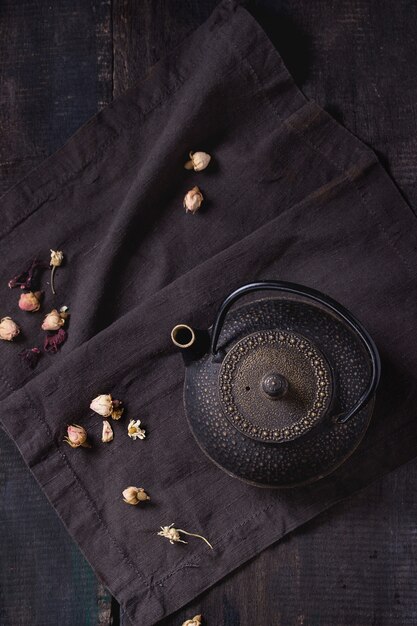 Black teapot with dry roses