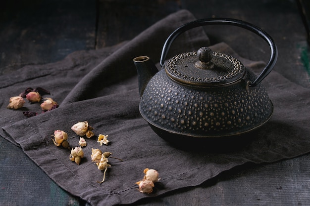 Black teapot with dry roses