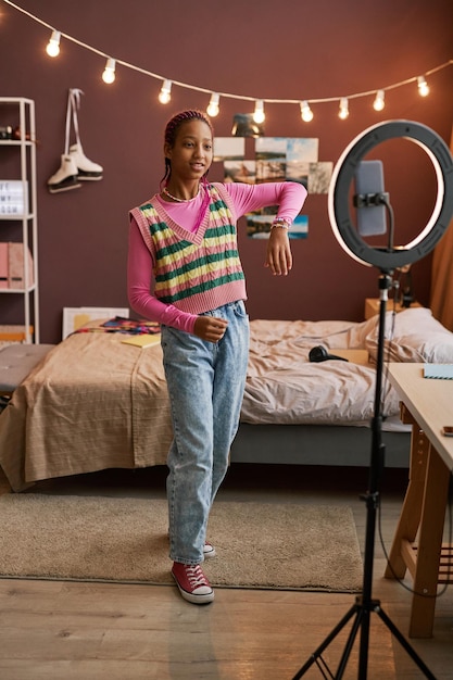 링 조명으로 집에서 댄스 비디오를 녹화하는 흑인 십대 소녀